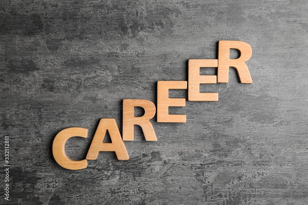 Fototapeta premium Word CAREER made with wooden letters on grey stone background, flat lay