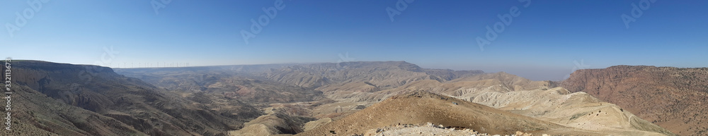 Panorama of Jordanian nature landscape at Tafilah Governorate, looking to Ma'an governorate in Dana neighborhood. Wind farm in the far distance. 