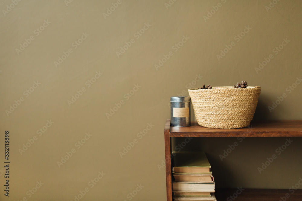 Modern minimal interior design concept. Straw basket, books on wooden stack on olive background. - obrazy, fototapety, plakaty 
