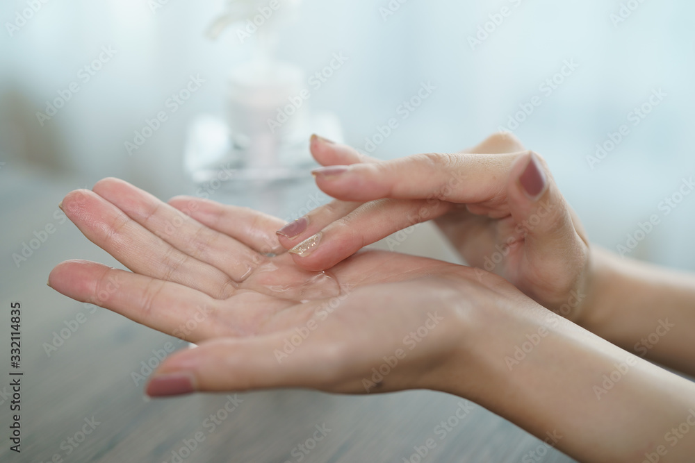Female hands using wash hand sanitizer gel pump dispenser. Clear sanitizer in pump bottle, for killing germs, bacteria and virus. - obrazy, fototapety, plakaty 