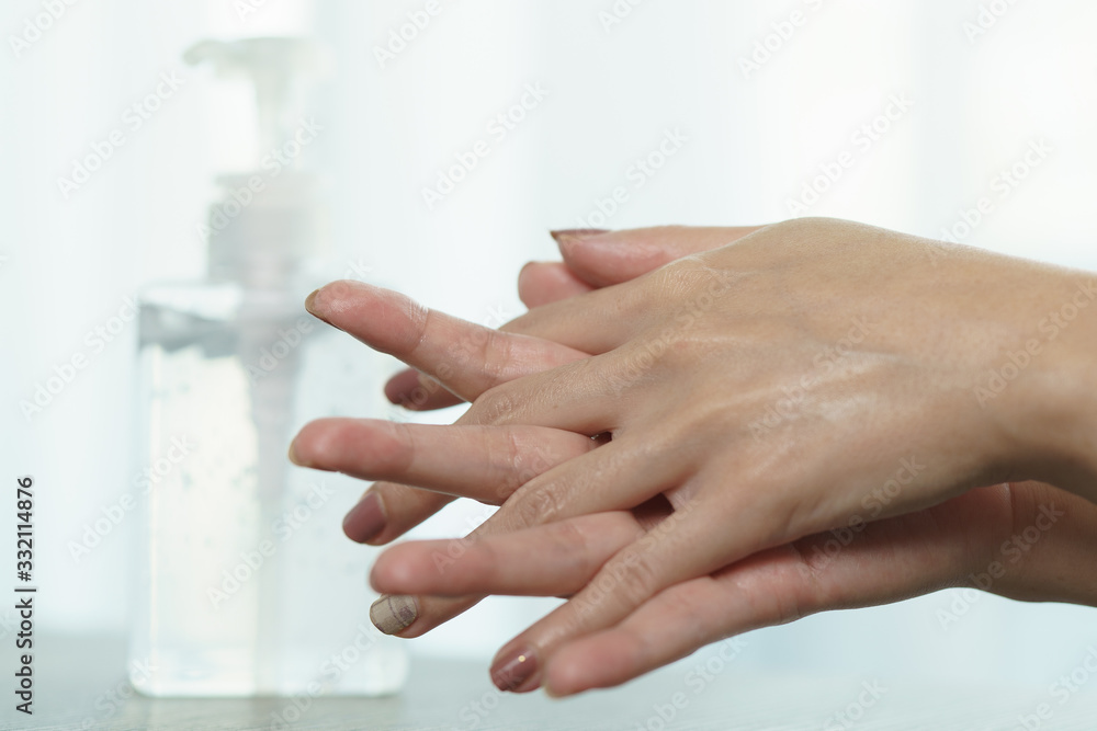 Plakat Female hands using wash hand sanitizer gel pump dispenser. Clear sanitizer in pump bottle, for killing germs, bacteria and virus.