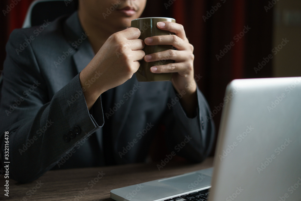Man working from home using computer and drinking cup of tea, closeup portrait indoor. Man working from home using computer and drinking cup of tea, closeup portrait indoor.
