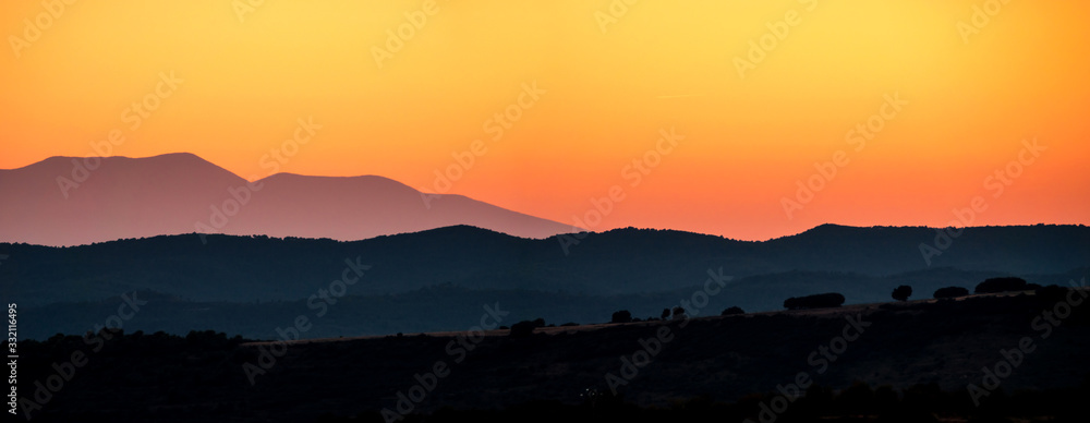 Obraz premium Mountains silhouette sunset skyline red orange colours