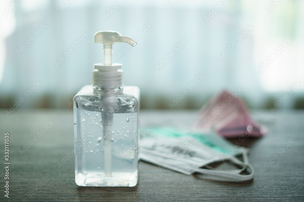 Antibacterial transparent hand sanitizer gel in a plastic bottle with surgical mask corona virus (covid-19) text written. Antibacterial transparent hand sanitizer gel in a plastic bottle with surgical mask corona virus (covid-19) text written.