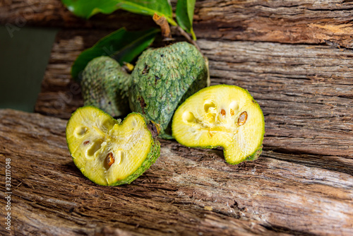 Fresh hybrid fruit of atemoia (Annona cherimolia Mill x Annona squamosa L.) in matedes on wooden background photo