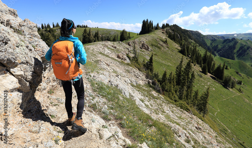 Woman hiker enjoy the view stand at cliff edge on mountain top