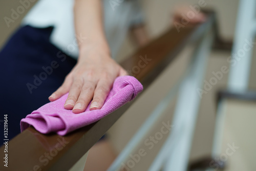 Woman hand with micro fiber cloth and detergent spray cleaning stairs at home.