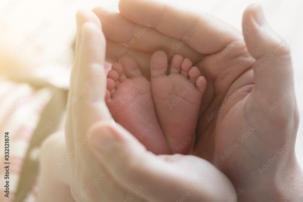 A close-up tiny baby feet. Childcare, safety and education concept. A close-up tiny baby feet. Childcare, safety and education concept.