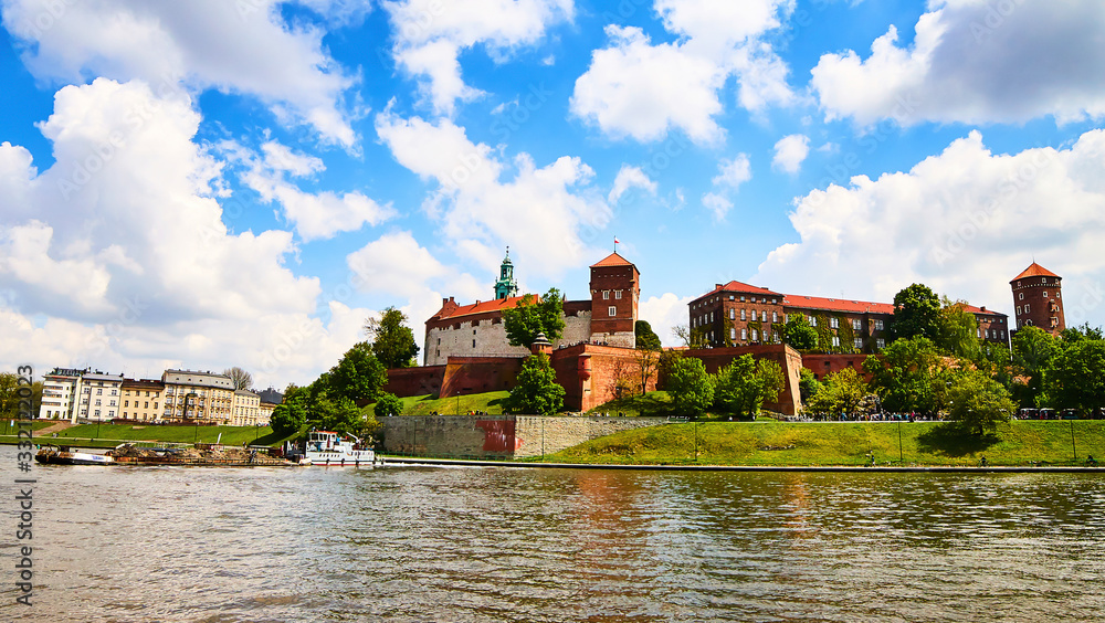 Fototapeta premium Wawel castle - famous landmark in Krakow Poland. Picturesque landscape on coast Vistula river during the sunny day.