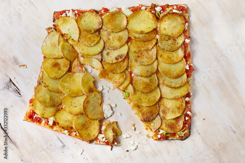 Tart Flambe or Flammkuchen on wooden cutting board, traditional Alsatian pie, rustic style, top view. photo