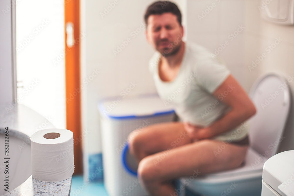 Fototapeta premium Man in the bathroom suffering from stomach pain