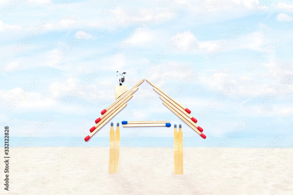 Fire insurance, Shape of House made of matches. abstract house made with matches, on the sand beach. Sea view during daytime with blue sky background. Concept of home protection insurance Fire insurance, Shape of House made of matches. abstract house made with matches, on the sand beach. Sea view during daytime with blue sky background. Concept of home protection insurance