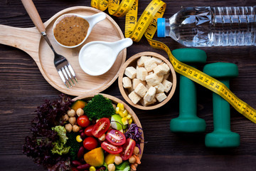 Diet Healthy food and lifestyle health concept. Sport exercise equipment workout and gym background with nutrition detox salad for fitness style. Healthy Concept