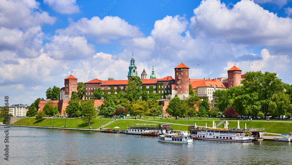 Naklejka premium Wawel castle - famous landmark in Krakow Poland. Picturesque landscape on coast Vistula river during the sunny day.