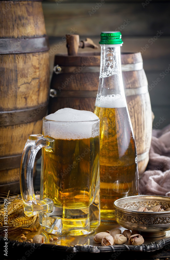 Light frothing beer in a glass, on an old background. Light frothing beer in a glass, on an old background.