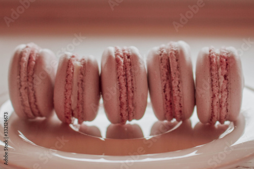 Strawberry french macarons closeup. Fresh and colourful on pink background