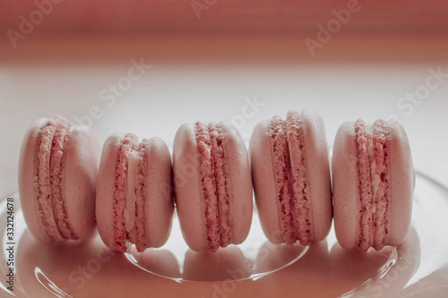 Strawberry french macarons closeup. Fresh and colourful on pink background