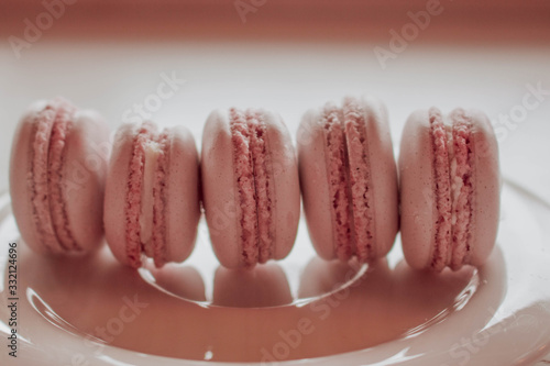 Strawberry french macarons closeup. Fresh and colourful on pink background