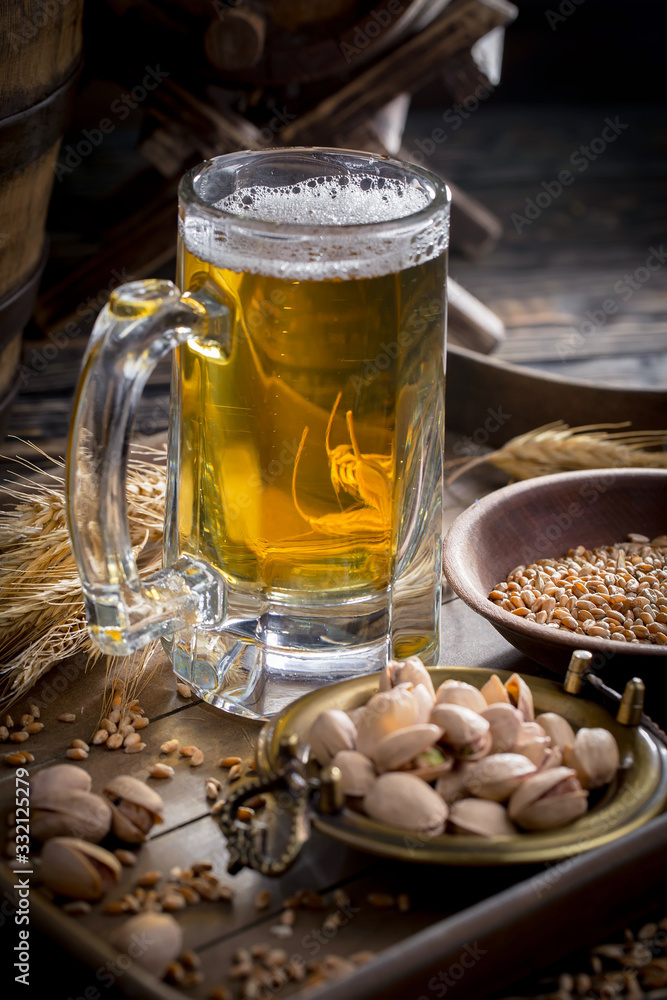 Light beer in a glass on a table in composition with accessories on an old background Light beer in a glass on a table in composition with accessories on an old background