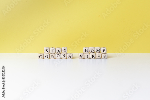 Coronavirus and stay home  inscription of wooden blocks   on yellow background. fight covid-19 corona virus symptoms. people fight virus concept. corona viruses vaccine concept end of 2019-ncov.  photo