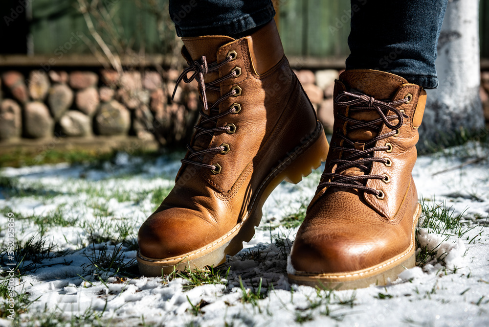 Woman wearing leather boots in winter frozen nature. Woman wearing leather boots in winter frozen nature.