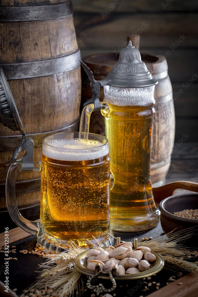 Light frothing beer in a glass, on an old background. Light frothing beer in a glass, on an old background.