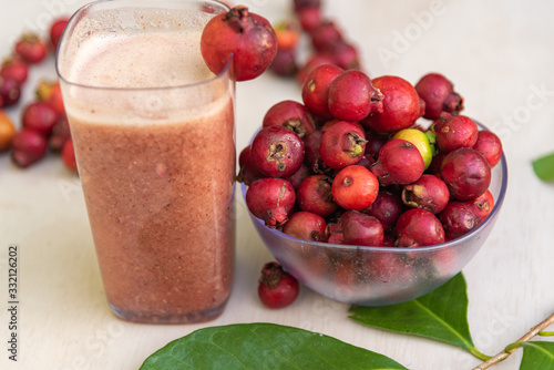 Glass of juice and fruits of red aracá (Psidium cattleyanum Sabine) in natura