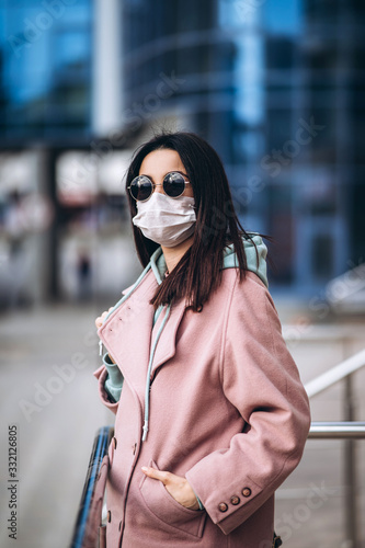 Female in medical protective mask outdoors in the empty city. Health protection and prevention of virus outbreak, coronavirus, COVID-19, epidemic and pandemic, quarantine concept