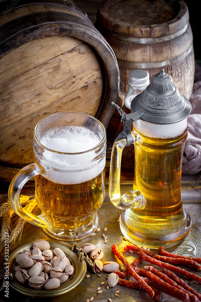 Light frothing beer in a glass, on an old background. Light frothing beer in a glass, on an old background.