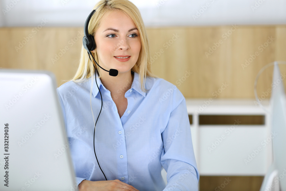 Call center. Blonde business woman sitting in headset at customer service office. Concept of telesales business or home office occupation Call center. Blonde business woman sitting in headset at customer service office. Concept of telesales business or home office occupation