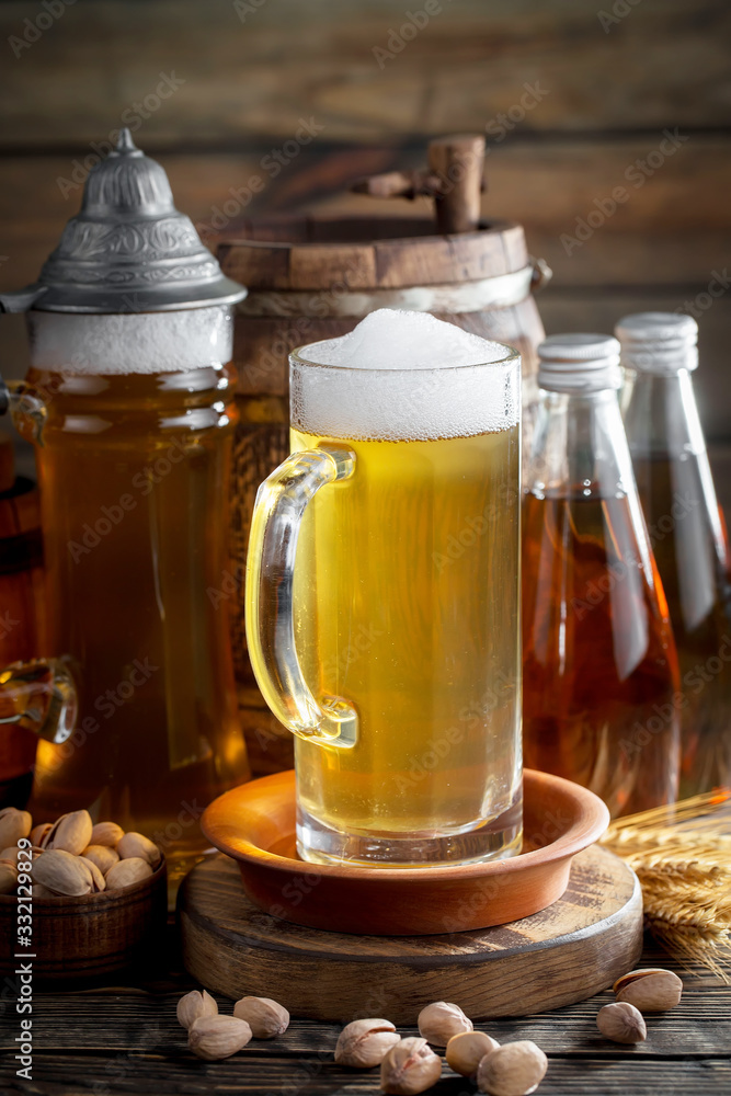 Light frothing beer in a glass, on an old background. Light frothing beer in a glass, on an old background.