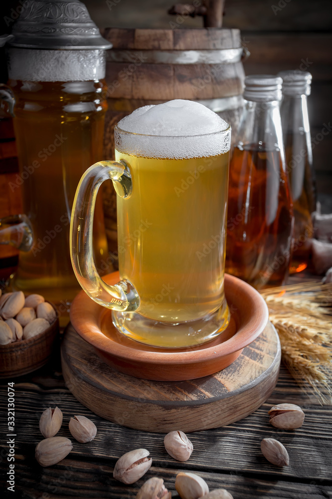 Light frothing beer in a glass, on an old background. Light frothing beer in a glass, on an old background.