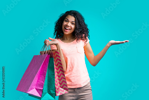Attractive young dark skinned woman with a bunch of shopping bags