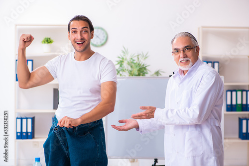 Doctor dietician and happy patient wearing large trousers © Elnur