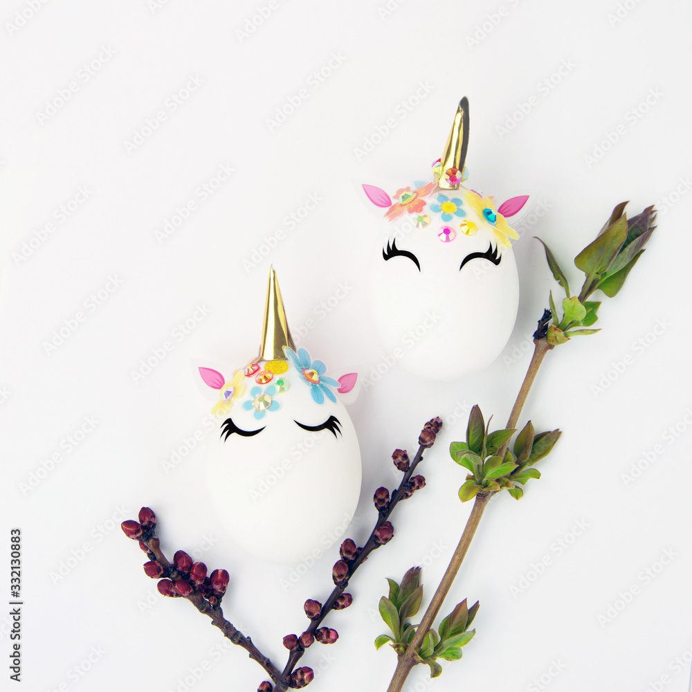 Easter concept. Unicorns shaped eggs. And twigs with buds and blooming leaves
