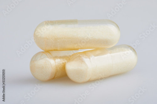 Transparent gelatin capsules with zink powder on white background. Pharmaceutical concept.