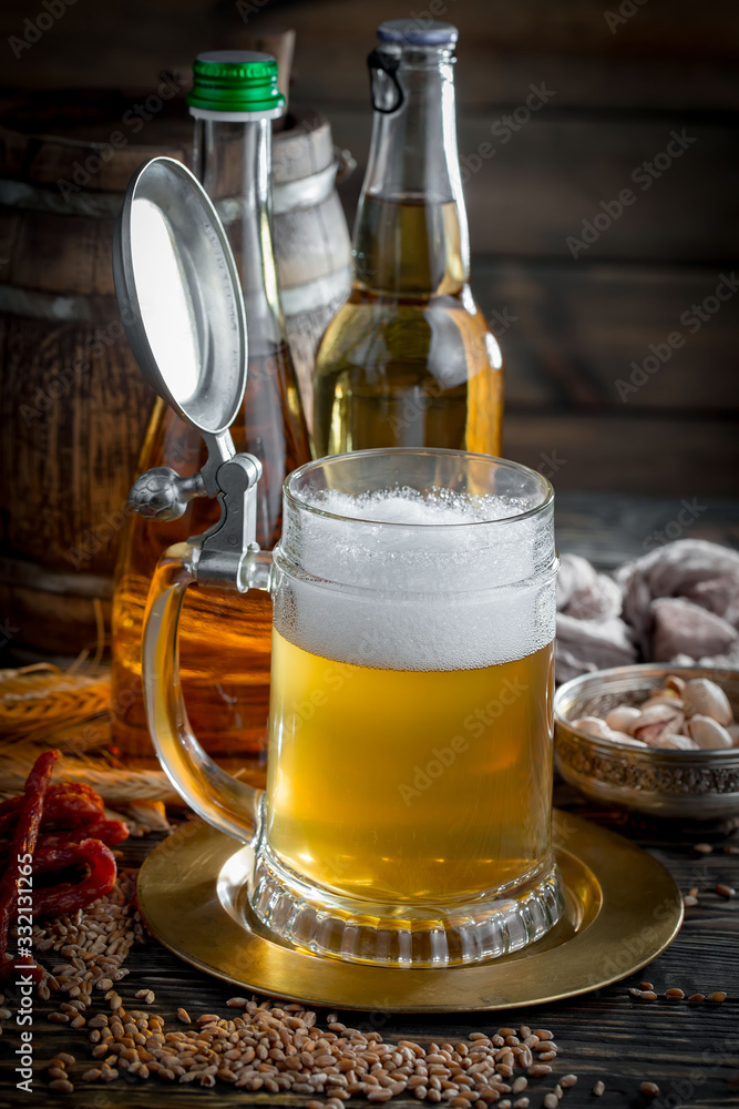 Light frothing beer in a glass, on an old background. Light frothing beer in a glass, on an old background.