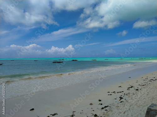 Traumkulisse, Fernweh und Karibik feeling am weißen Strand auf Sansibar, mit türkisen Meer und Schäfchenwolken im Hintergrund © Angelika Beck