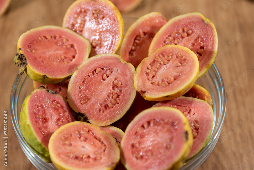 guava (Psidium guajava) fruits in halves in bowl on white background... guava (Psidium guajava) fruits in halves in bowl on white background...