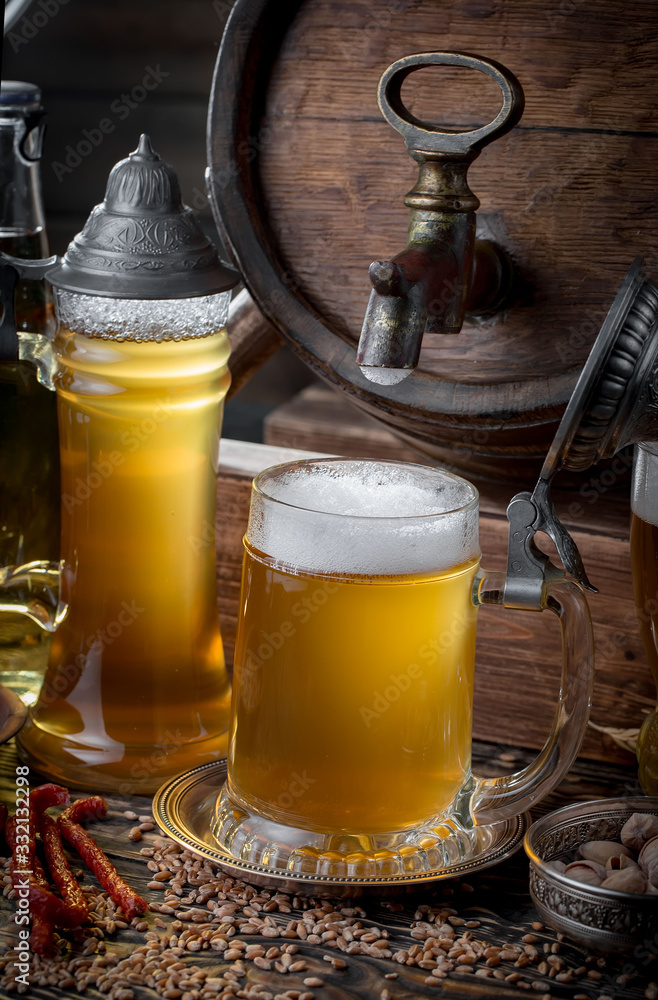 Light frothing beer in a glass, on an old background. Light frothing beer in a glass, on an old background.