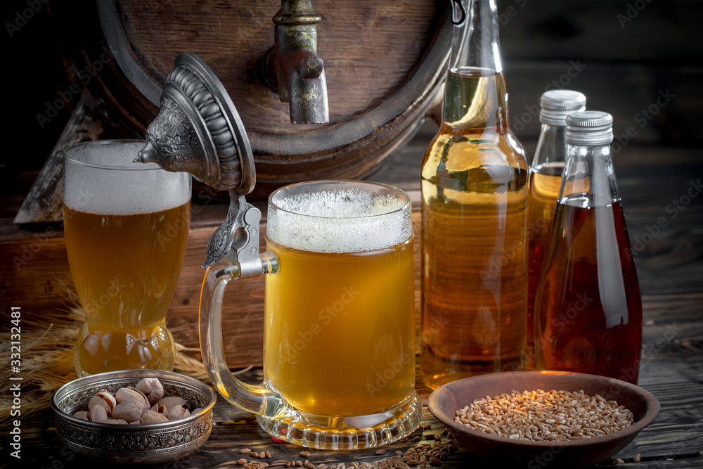 Light frothing beer in a glass, on an old background. Light frothing beer in a glass, on an old background.