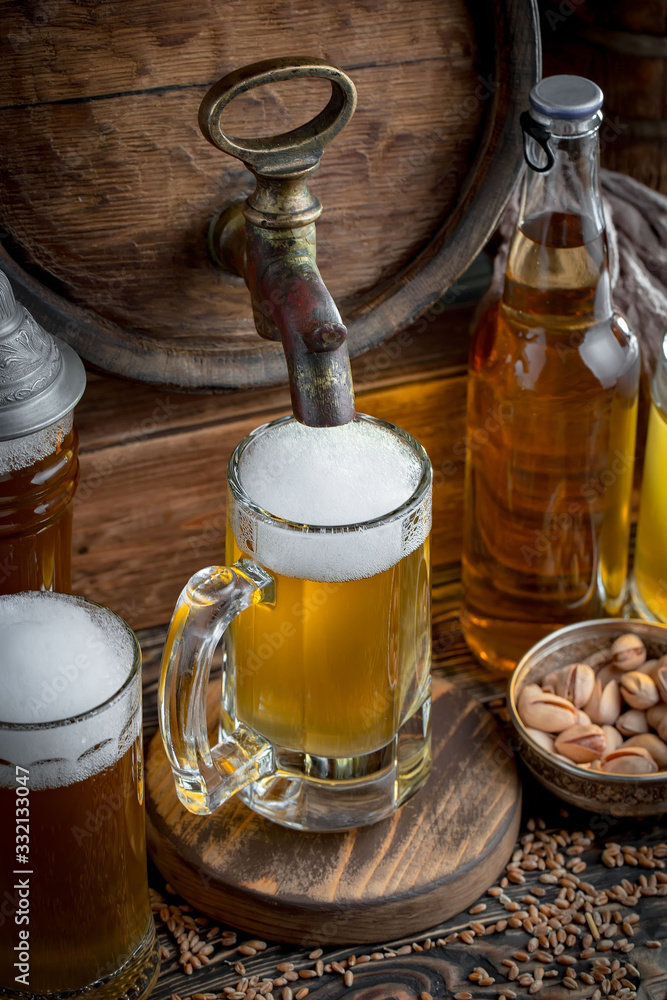 Light frothing beer in a glass, on an old background. Light frothing beer in a glass, on an old background.