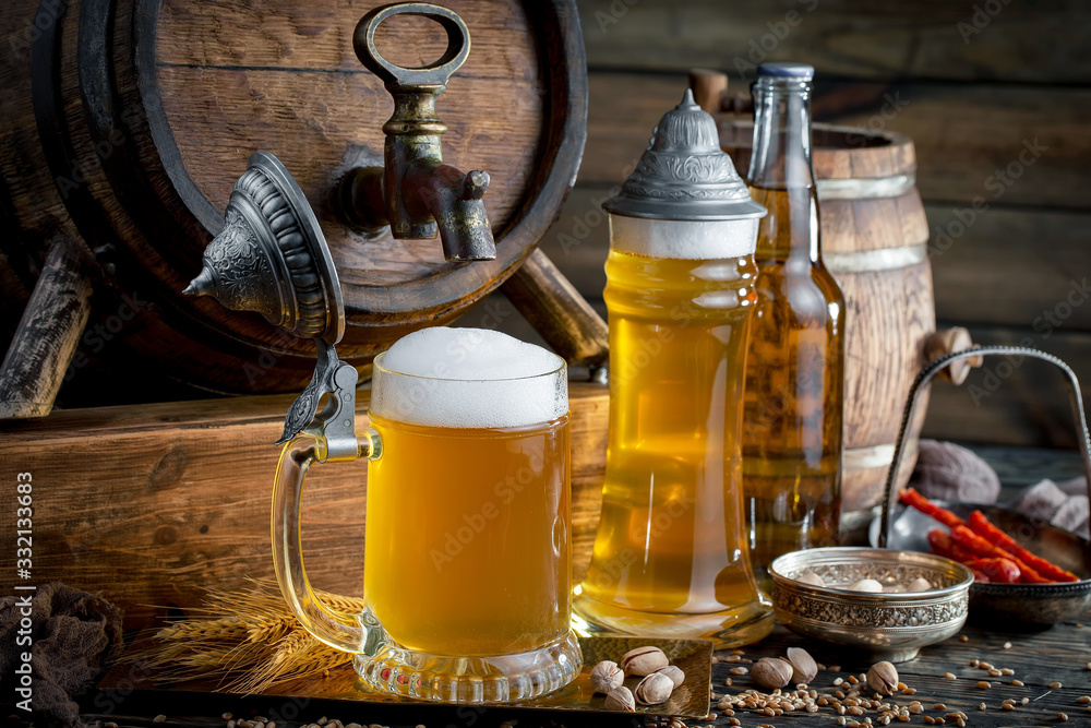 Light frothing beer in a glass, on an old background. Light frothing beer in a glass, on an old background.