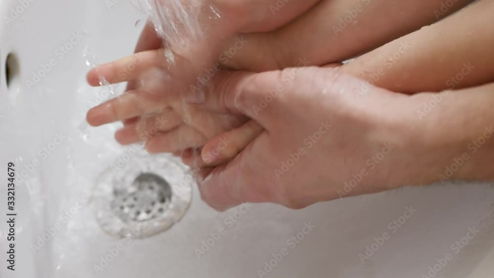 Father helps wash his little son's hands. Close-up dad washes hands to a child Father helps wash his little son's hands. Close-up dad washes hands to a child