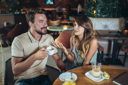 Fotografie Young couple arguing while sitting and drinking coffee in restaurant