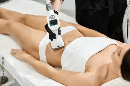 Obraz na płótnie close-up of woman belly with professional massager w salonie