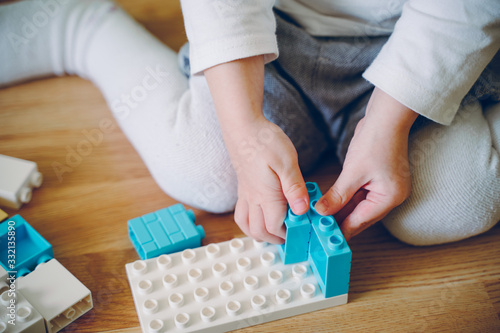 Little girl play a building plastic blocks. Logic game for children.