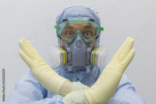 Man in chemical protective suit making stop gesture on white background.Focus on hands.