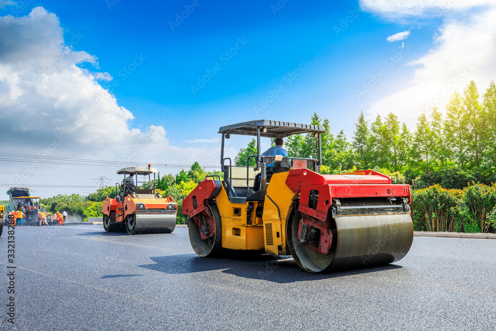 Construction site is laying new asphalt road pavement,road construction workers and road construction machinery scene.highway construction site landscape. Construction site is laying new asphalt road pavement,road construction workers and road construction machinery scene.highway construction site landscape.