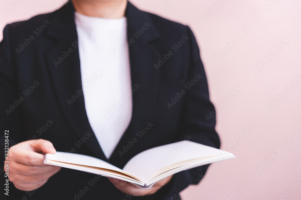 Businesswomen reading a book, blurry background.